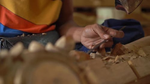 Artisan Carving Intricate Wood Sculpture with Hand Tools