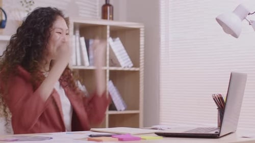 Aproveitando o momento. No trabalho, um designer asiático se senta em uma mesa com seu laptop, tablet e documento