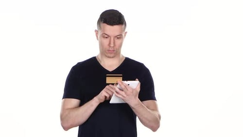 Man Uses Tablet for Online Shopping with Credit Card