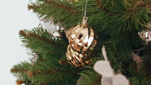 Golden Christmas Ornaments on Decorated Evergreen Tree