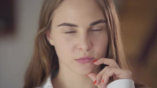 Close-up Portrait of Pretty Caucasian Girl with Different Colored Eyes Thinking and Looking Away