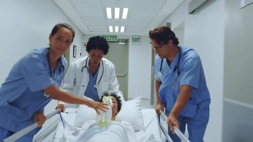 medical team pushing emergency stretcher bed in the corridor at hospital