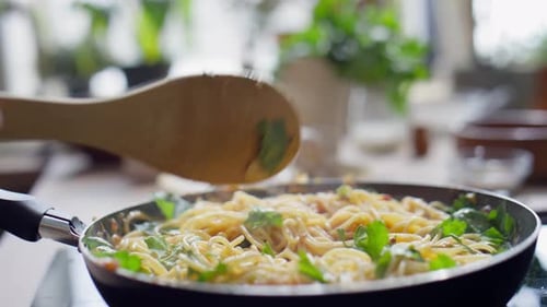 Stirring Spaghetti with Greens in a Pan