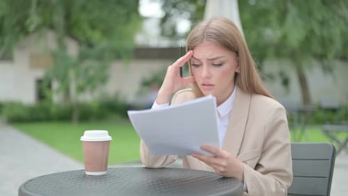 Confused Woman Reads Documents Outside