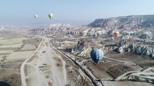 Hot Air Balloons Floating Over Rural Landscape