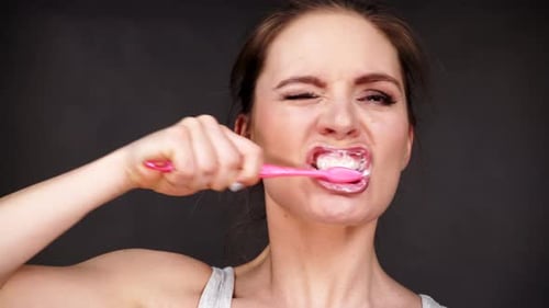 Young Woman Brushing Her Teeth Close Up