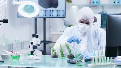 In High-end Modern Research Facility Scientist in Coverall Is Working on the Computer