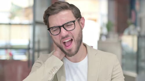 Young Adult Man Rubbing Back of Neck
