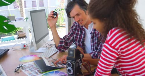 Team Collaborate at Desk with Computer and Photos