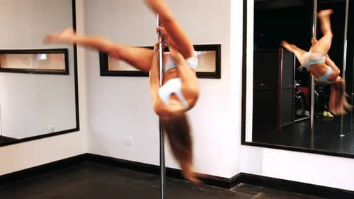 Athletic Woman Performing Pole Dance in Studio