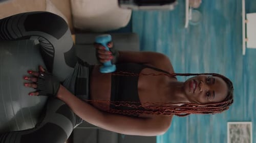 Woman Exercising on Fitness Ball with Dumbbell