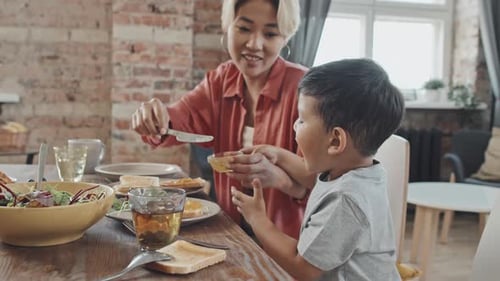 Mother Preparing Breakfast for Her Child at Home