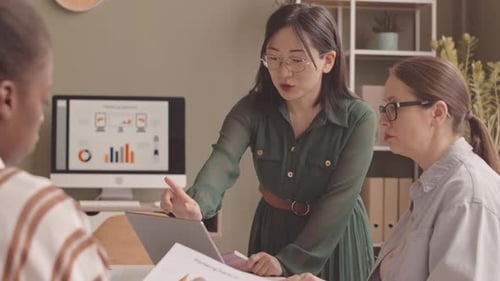 Business Team Discussing Marketing Statistics at Office Desk