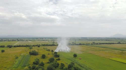Aerial Flight People Burn Dry Grass in the Fields. Fire in the Field and Flying Over a Smoky Field