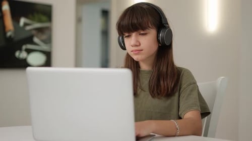 Teenage Girl With Laptop and Headphones At Home