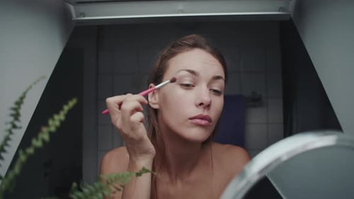 Young Woman Applying Eye Makeup at Home