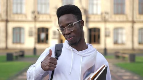 Smiling Student Gives Thumbs Up on Campus