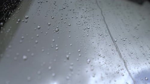 Rain Drops Running Down Reflective Gray Surface