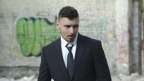 Man in Suit Corrects Necktie Looks Around and Flees at Ruins