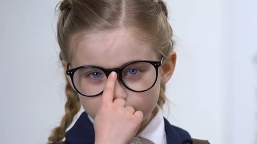 Primer plano de ajuste de anteojos de colegiala inteligente, educación del alumno de la escuela primaria