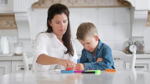 Beautiful Mom and Cute Little Son Enjoying Drawing Picture Together Using Multicolored Felttip Pen