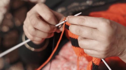 Nahaufnahme von Frauenhänden, die eine neue Reihe mit schwarzer Wolle stricken. 4k Filmmaterial von Strick Work Tie Up Hand wo