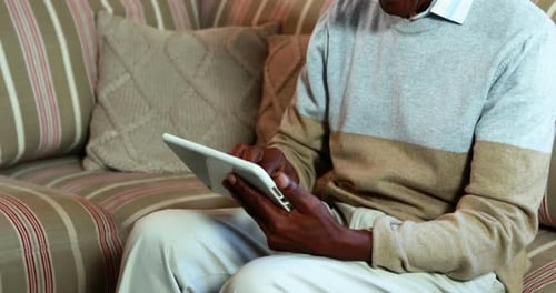 Senior Man Using Tablet Device at Home