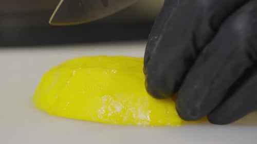 Knife Cuts Yellow Mango on Cutting Board
