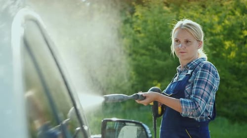 Woman Power Washing Car on Sunny Day