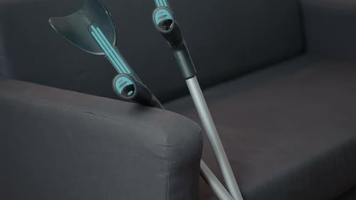 Crutches Resting on a Dark Grey Couch