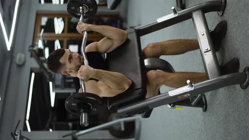Handsome Bodybuilder Doing Weight Lifting in Gym