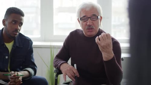 Business Meeting with Man in Wheelchair Speaking