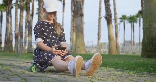 Girl Riding on Skateboard in Tropical Park. Active Outdoor Sport for Kids.