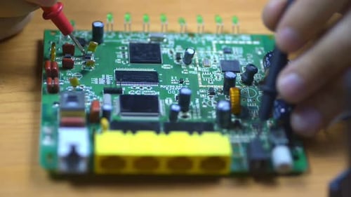 Closeup View of Man Engineer Working with Electronic Device at Table in Office. Irrl