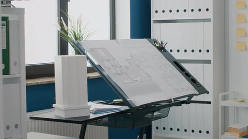 Nahaufnahme von Bauplänen, Plan und Gebäudemodell auf Tisch im leeren Raum, der für den Bau genutzt wird