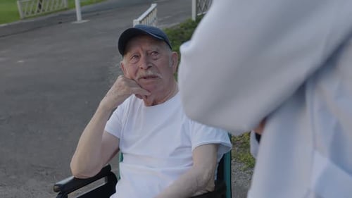 Senior Man in Wheelchair Talking to Doctor