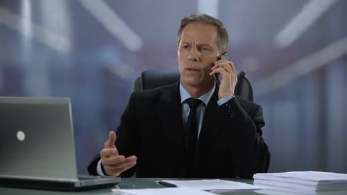 Professional Man Talking on Phone at Desk in Office