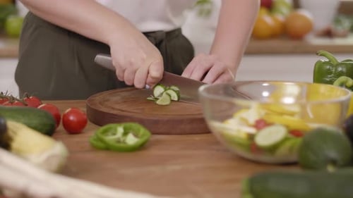 Handheld view of wooden board and freshness cucumber slices