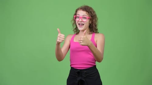 Young Woman Gives Two Thumbs Up on Green Screen