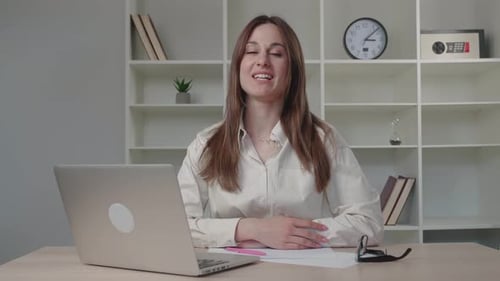 Smiling Woman Talking at Desk with Laptop