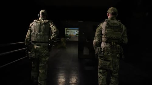 Two Soldiers Facing Down Dark Hallway in Uniforms