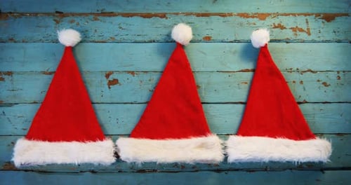 Three Santa Hats on Blue Wooden Background