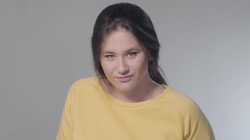 Woman Smirks in a Close Up Studio Shot