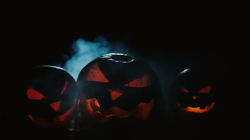 Scary Carved Halloween Pumpkins with Smoke at The Background