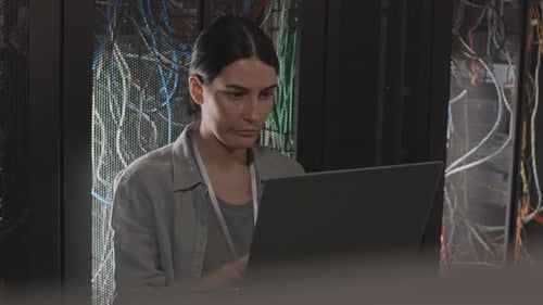 Woman Working by Rack in Server Room