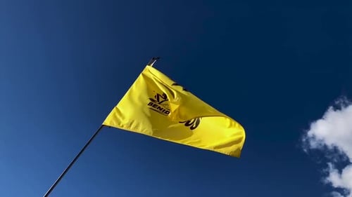 Yellow Flag Waves Against a Clear Blue Sky