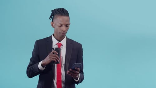 Man Drinking Coffee and Looking at Phone