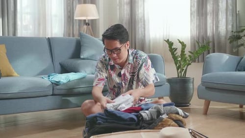 Man Packing Suitcase for Vacation at Home