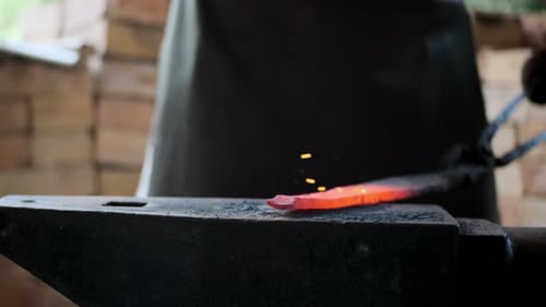Blacksmith Shaping Hot Metal on Anvil