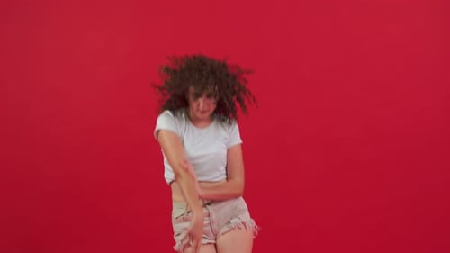 Energetic Young Woman Dancing with Curly Hair